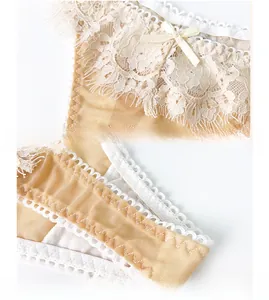 Detalle de encaje de pestañas y lazo en las bragas de malla beige para mujer