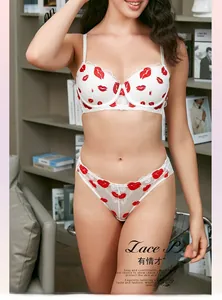 Dettaglio del set di lingerie in pizzo bianco con ricami a labbra rosse e floreali