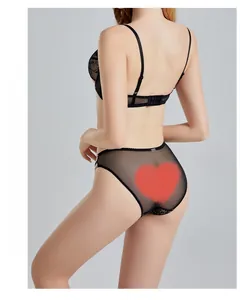 Dettaglio di set lingerie in pizzo nero con slip in mesh trasparente e ricami delicati