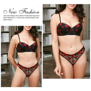 Dettaglio reggiseno in pizzo nero con ricami a labbra rosse e tessuto in mesh fine