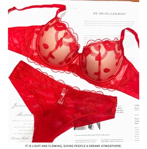 Dettaglio di un set di lingerie in pizzo rosso con mesh e ricami a forma di labbra