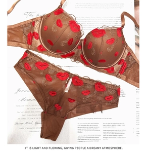 Dettaglio di lingerie marrone scuro con ricamo labbra rosse e pizzo a rete