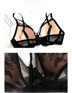 Dettaglio reggiseno in pizzo nero con ricamo floreale e spalline doppie su sfondo di marmo