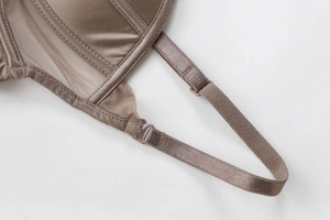 Macro shot of adjustable straps and satin mesh stitching on a coffee colored bra