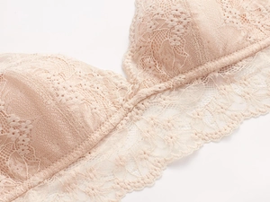 Detalle del encaje floral en un sujetador bralette de triángulo sin aros nude
