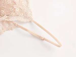 Detalle de encaje rosa con motivos florales y tirante elástico ajustable de textura suave
