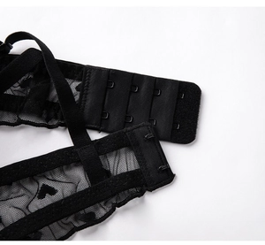 Détail de soutien-gorge en dentelle noire à motif cœurs avec agrafage à quatre rangées