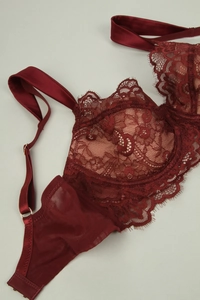 Detail of burgundy eyelash lace bra showing satin straps and gold metal adjustments