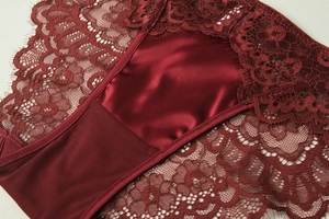 Detail of burgundy satin and eyelash lace stitching on French style lingerie set