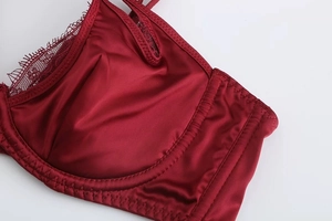 Close-up detail of wine red satin bra cups with delicate eyelash lace and soft underwire