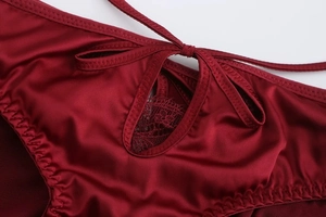 Detailed macro view of wine red satin lingerie with delicate lace and silk bow