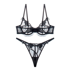Detailed close-up of black lace floral embroidery and bow details on the lingerie set