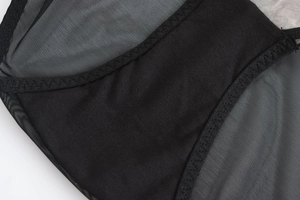 Détail de l'entrejambe de lingerie en dentelle noire avec coutures renforcées et maille