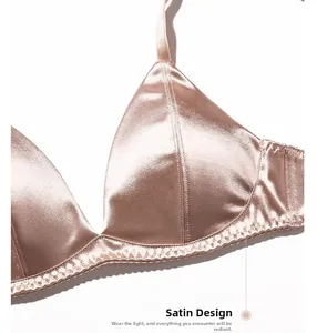 Detailed close-up of champagne satin fabric with delicate lace trim on a soft bra