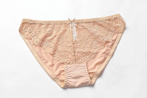 Bragas de encaje beige con tejido sedoso y un pequeño lazo en la cinturilla delantera