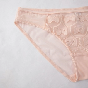 Close-up of pink breathable mesh panties with delicate embroidered bow patterns