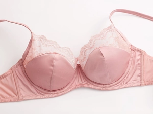 Dettaglio reggiseno in raso rosa e pizzo con ricami raffinati e supporto con ferretto