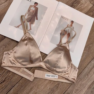 Detailed view of champagne satin bra with fabric composition tag and thin straps