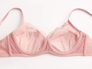 Dettaglio ravvicinato del reggiseno in pizzo rosa chiaro con ricami e tessuto a rete
