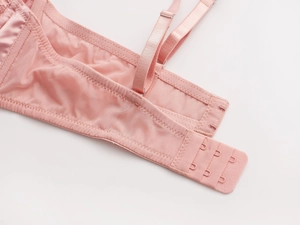 Dettaglio della schiena del reggiseno rosa con chiusura a tre ganci e ali in mesh