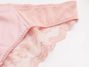 Close-up of pink lace stitching and smooth fabric texture on women's underwear