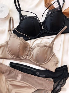 Flat lay of satin lace bras with front buckle closure and matching lingerie sets
