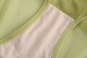 Détail en maille vert clair respirante et doublure en coton rose avec coutures précises