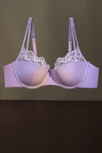 Détail d'un soutien-gorge en satin lilas avec dentelle blanche et doubles bretelles