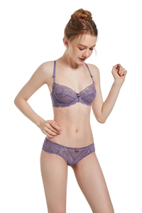 Detailed view of purple lace bra set with delicate bow details on model on white background