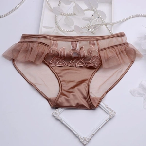 Gros plan sur la culotte en satin champagne avec broderie de feuilles et volants
