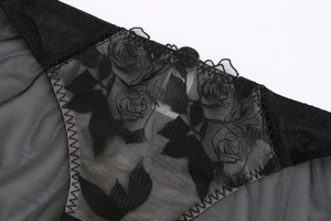 Detalle de tela de malla negra con bordado de rosas y bordes de encaje fino