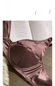 Dettaglio del reggiseno in raso viola con pizzo che mostra il tessuto liscio e il supporto