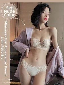 Detailed close-up of French lace bra set in beige showing delicate floral embroidery texture