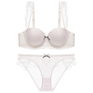 Detailed view of off-white lace lingerie set with ruffles and contrasting bows