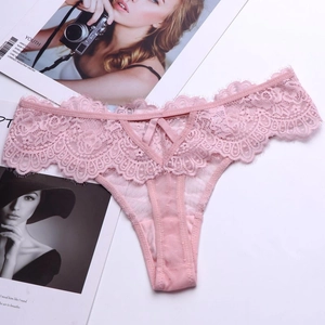 Detail eines rosa Spitzen-Strings mit süßer Schleife und halbtransparentem Netzstoff