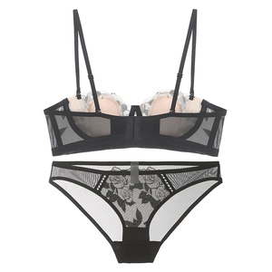 Flat lay of black and white lace lingerie set featuring rose floral embroidery and sheer mesh