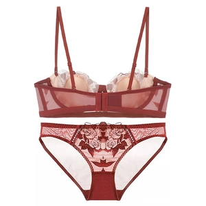 Detailed close-up of dark red lace lingerie set with embroidery and mesh details