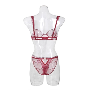Detail view of red lace lingerie set featuring intricate wave patterns on a mannequin