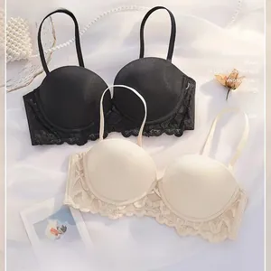 Details von eleganten schwarzen und beigen Spitzen-BHs mit glatten Cups und Perlen