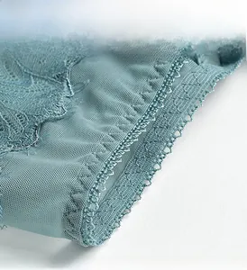 Close-up of floral embroidery lace and breathable mesh on teal blue panties