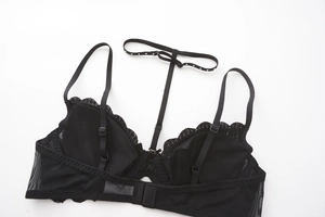 Detail view of black French lace bra featuring heart embroidery and back hook closure