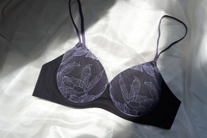 Détail de la dentelle florale violette sur bonnets de soutien-gorge noirs