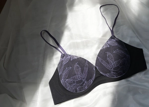 Détails de la dentelle florale violette sur tissu noir avec bretelles fines élastiques