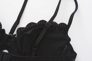 Close-up of black mesh fabric with lace trim and adjustable strap on a French style bra