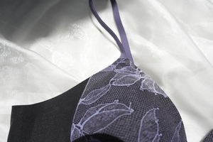Détail de la broderie en dentelle violette et du tissu en maille sur un soutien-gorge