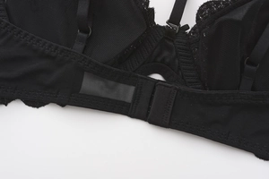 Detailed macro view of black lace bra back closure with adjustable straps and mesh