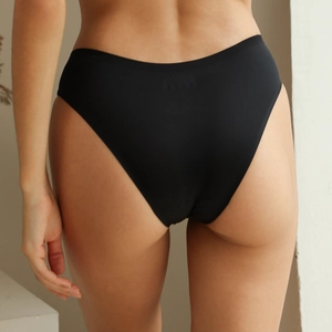 Back view of seamless black low-waist briefs with breathable fabric on female model