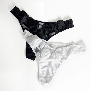 Details von Blumenstickerei und Satinstoff an sexy Low-Rise-Spitzenstrings für Damen