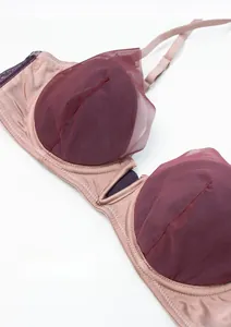 Detail view of deep V-neck lace bra with pink mesh and soft boning for support