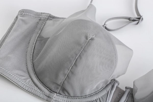 Detailed close-up of gray mesh bra with sheer breathable fabric and fine stitching